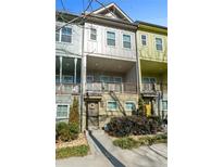 Charming townhome featuring a covered balcony, decorated door and manicured landscaping at 68 Adore Se Ct, Atlanta, GA 30315