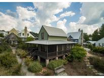 Inviting exterior view with a charming screened-in porch and beautifully landscaped grounds at 1015 Loliver Ln, Chattahoochee Hills, GA 30268