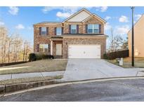 Charming two-story brick home with a two-car garage and well-maintained front yard at 11229 Wind Ridge Dr, Hampton, GA 30228