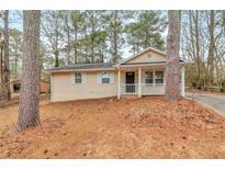 Charming one-story home with a welcoming front porch and a well-maintained front yard surrounded by mature trees at 949 Rock Oak Ln, Lawrenceville, GA 30046