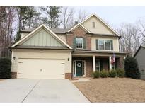 Charming two-story home with brick and siding, a two-car garage, manicured lawn, and covered front porch at 149 Red Fox Dr, Dallas, GA 30157