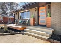 Inviting front entrance with a modern door, stylish planters, and a cozy seating area on the porch at 3590 Se Crestview Se Dr, Smyrna, GA 30082