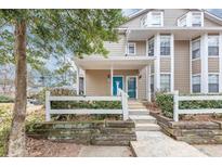 Charming townhome with a bright blue front door and a well-maintained white picket fence at 6422 Pinebark Way, Morrow, GA 30260