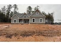 Charming single-Gathering home featuring a covered porch, neutral paint, and classic architectural detailing at 1130 Holly Dr, Loganville, GA 30052