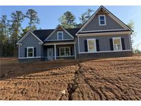 Charming one-story home with gray siding, a covered front porch, and dark shutters offers great curb appeal at 1130 Holly Dr, Loganville, GA 30052