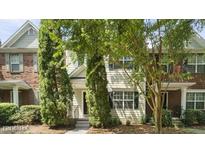 Charming townhome featuring a mix of brick and siding, complemented by mature trees and well-maintained landscaping at 1202 Charleston Ct Cir, Woodstock, GA 30188