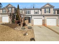 Charming townhouse showcasing a well-manicured lawn, a single-car garage, and neutral-colored siding at 3972 Carlinswood Way, Stone Mountain, GA 30083