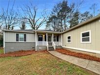 Charming home featuring a welcoming front porch and manicured landscaping at 1641 Pendley Dr, Austell, GA 30168