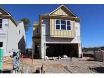 A new construction two-story home showcases its facade and a welcoming two-car garage, set against a clear blue sky at 1975 William Glen St, Dacula, GA 30019