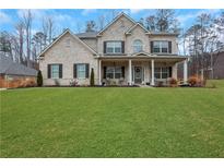 Charming two-story home with brick exterior, a spacious front yard, and a welcoming covered porch at 3808 The Great Dr, Atlanta, GA 30349