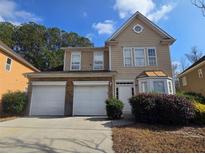 Inviting two-story home with attached two-car garage and manicured landscaping at 7330 Taloga Ln, Union City, GA 30291