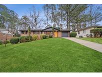 Charming single-story home with lush green lawn, brick facade, and mature trees at 2867 Dresden Way, Atlanta, GA 30341