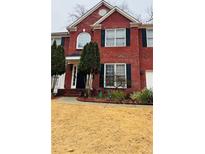 Inviting two-story brick home featuring a manicured front yard and charming architectural details at 3008 Stockbridge Way, Dacula, GA 30019