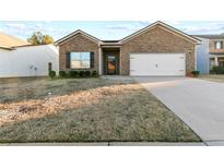 Charming single story home with brick facade, well-maintained lawn, and attached two-car garage at 11181 Wind Ridge Dr, Hampton, GA 30228