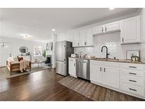 Bright kitchen with white cabinets, stainless appliances, and granite countertops, seamlessly flowing into the living area at 1612 Alder Se Ct, Atlanta, GA 30317