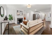 Cozy living room with a decorative fireplace, modern lighting, and stylish furnishings on gleaming hardwood floors at 1612 Alder Se Ct, Atlanta, GA 30317