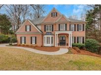 Charming brick two-story home with a well-manicured lawn and inviting front entrance at 1355 Zephyr Ct, Cumming, GA 30041