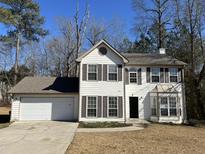 Charming two-story home featuring a well-manicured lawn, attached garage and classic architectural design at 225 Whirlwind Ct, Atlanta, GA 30349