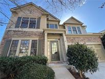 Charming two-story home featuring a stone facade, green shutters, and attached garage at 3740 Crowchild Dr, Cumming, GA 30041