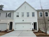 Charming townhouse with a white brick facade, a two-car garage, and a well-manicured lawn at 409 Carrera Ln, Acworth, GA 30102