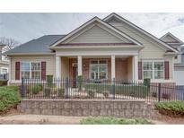 Charming single-story home featuring a brick and siding facade, covered porch, and well-maintained landscaping at 950 Brook Knoll Ln, Cumming, GA 30041