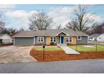 Charming renovated single-story home with a driveway, manicured lawn, and stylish blue front door at 5412 Peak Sw St, Mableton, GA 30126