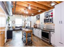Bright, open kitchen with stainless steel appliances, white cabinets, and an island at 1661 La France Ne St # 216, Atlanta, GA 30307