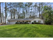 Charming white brick home featuring a spacious, well-manicured front lawn and inviting curb appeal at 3372 Pine Meadow Nw Rd, Atlanta, GA 30327