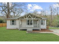 Charming home featuring a covered front porch, manicured lawn, and neutral exterior color scheme at 2923 Hall Se Dr, Smyrna, GA 30082