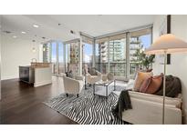 Bright living room with floor-to-ceiling windows and skyline views, creating an inviting and modern space at 1080 Peachtree Ne St # 2207, Atlanta, GA 30309