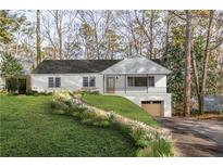 Charming home featuring a stone walkway, covered porch, and a drive under garage at 4103 Statewood Ne Rd, Atlanta, GA 30342