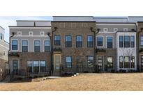 Charming townhome featuring a brick facade, multiple windows, and inviting entryways at 2141 Burnside Nw Dr, Atlanta, GA 30318