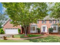 Beautiful brick two-story house with a well-manicured front yard and attached two car garage at 2626 Delridge Dr, Lilburn, GA 30047