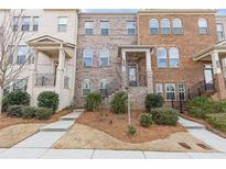 Charming townhome with brick facade, manicured landscaping, and inviting front entry at 3374 Grey St, Duluth, GA 30096