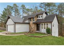 Charming home with stone accents, landscaped yard, and attached two-car garage at 5368 Stafford Nw Dr, Lilburn, GA 30047