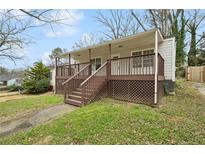 Inviting home with a charming covered front porch and nicely landscaped front yard at 214 Maple St, Atlanta, GA 30354