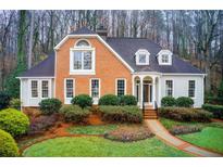Charming brick and siding home with manicured lawn and inviting entrance, nestled in a wooded setting at 6235 River Chase Cir, Atlanta, GA 30328
