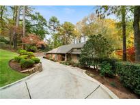 Charming one-story home with lush landscaping and a long driveway surrounded by mature trees at 5525 Whitner Dr, Sandy Springs, GA 30327