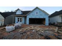 New construction home showing a garage and front porch with building supplies in the front yard at 2017 Ripple Park Bend, Canton, GA 30114