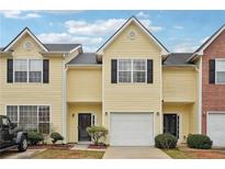 Inviting townhouse featuring a one-car garage, complemented by a well-maintained lawn and charming exterior at 2403 Brianna Dr, Hampton, GA 30228