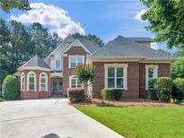 Stunning two-story brick home featuring manicured lawn, driveway, and mature landscaping at 1258 Mcallistar Dr, Locust Grove, GA 30248