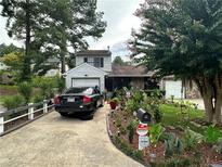 Charming home featuring mature landscaping, a long driveway, and an attached one-car garage at 709 Pine Tree Trl # 10A, Atlanta, GA 30349