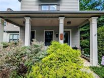 Inviting covered front porch with square columns and lush landscaping creates curb appeal at 3157 Oakdale Rd, Hapeville, GA 30354
