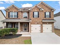 Charming two-story brick home featuring a well-manicured lawn and attached two-car garage at 4102 Dinmont Chase, Atlanta, GA 30349