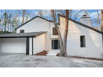 Striking white modern home featuring black trim, an attached garage and mature landscaping at 4830 Rebel Nw Trl, Sandy Springs, GA 30327