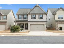 Two-story home featuring brick facade, two-car garage and well-maintained landscaping at 2098 Bridgewater Pass, Hampton, GA 30228