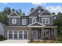 Charming two-story home with a brick garage and gray siding, exuding modern elegance and curb appeal at 4445 Beechnut Cir, Cumming, GA 30028