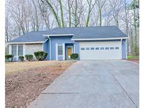 Charming single-story home featuring a stone facade, blue siding, and attached two-car garage at 5252 Biffle Rd, Stone Mountain, GA 30088