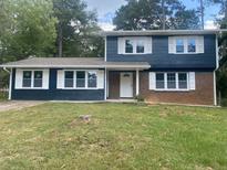 Charming split-level home featuring a brick accent, fresh paint, and bright white shutters and trim at 10664 Sandpiper Road Rd, Jonesboro, GA 30238