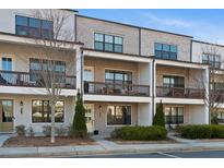 Charming townhome with brick facade, cozy balconies, and well-maintained landscaping at 127 Harlow Cir, Roswell, GA 30076